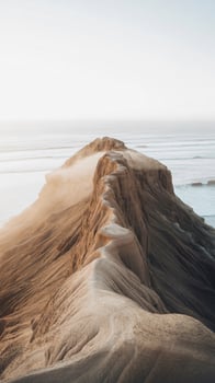 Sunlit rocky outcrop overlooking a calm ocean horizon photo