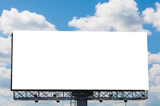 Expansive Blank Billboard Against a Vivid Blue Sky with Fluffy White Clouds photo