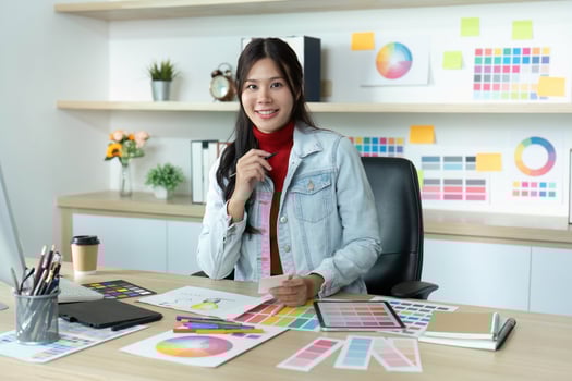 Smiling Designer Showcasing Color Palettes in Modern Workspace photo