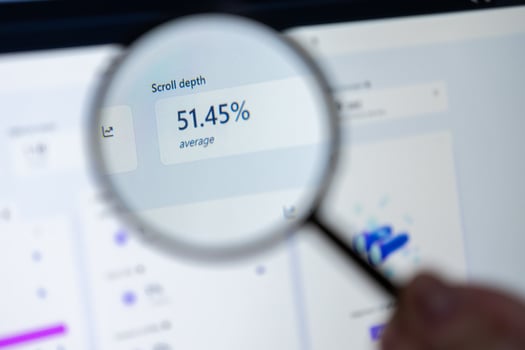 Magnifying glass inspecting key website scroll depth data on a computer screen, showcasing crucial digital marketing analytics to improve user engagement and web optimization efforts photo