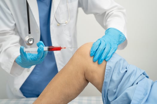 Asian doctor inject Hyaluronic acid platelet rich plasma into knee of senior photo