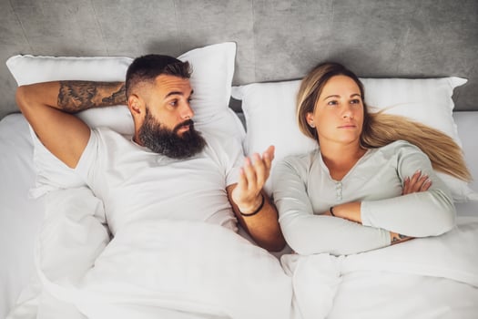 Above view of a man and woman lying apart on a couch, visibly upset after an intense argument. The image captures themes of relationship issues, love, and communication breakdown. photo