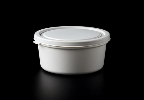 White plastic container with lid on black background photo