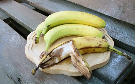 Rotten banana against ripe fruit background photo