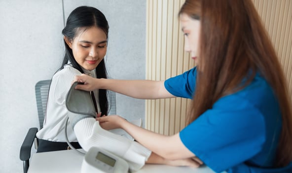 woman is having her blood pressure taken by another woman photo