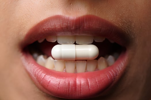 Close-up of young female with pill in mouth, healthcare and medical treatment concept photo