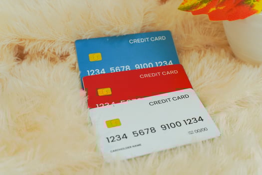 thee credit cards laying on yellow fur, financial technology concept photo
