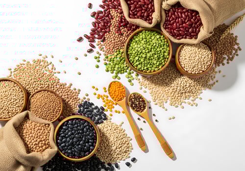 Assortment of dried beans and legumes in burlap bags and bowls isolated on white background photo
