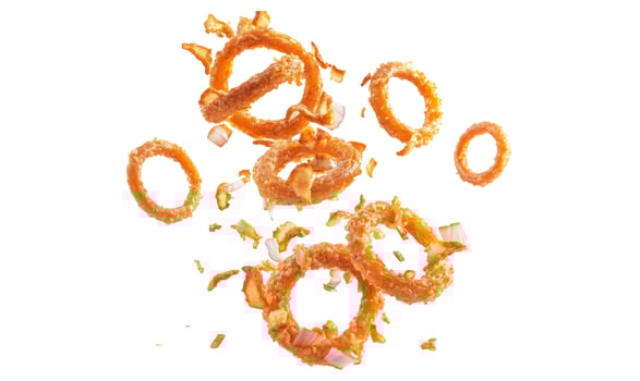 Flying crispy golden fried onion rings with scattered pieces on a clean white background photo
