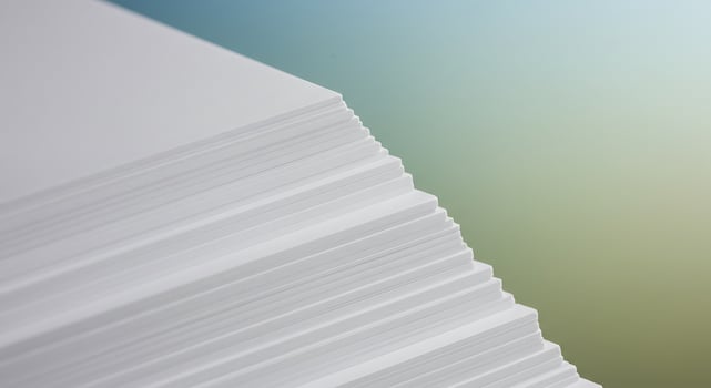 A stack of white paper on a blue background photo