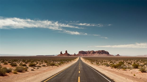 Under blue sky, a deserted highway in the middle of the desert stretches to the distant horizon, surrounded by arid and dry terrain as well as majestic mountains in the distant. Natural background. photo
