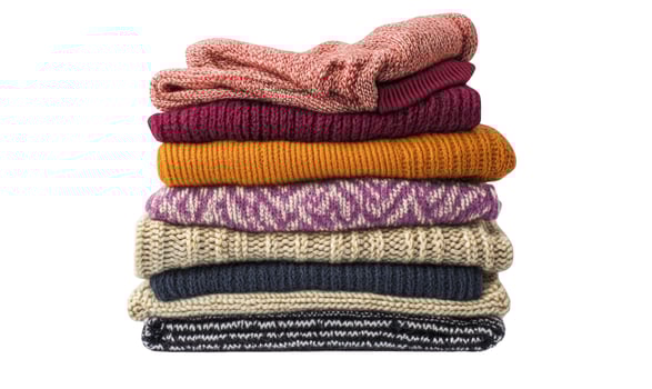 Stack of Colorful Knitted Sweaters on White Background, Winter Clothing photo