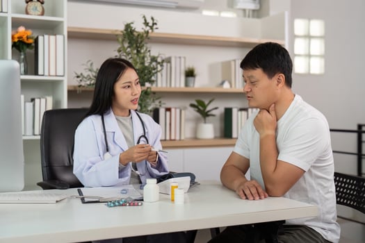 Doctor-Patient Interaction. Female doctor explaining health issues to male patient in modern office. photo