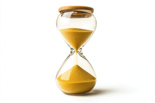 Glass hourglass with golden sand flowing isolated on white background photo