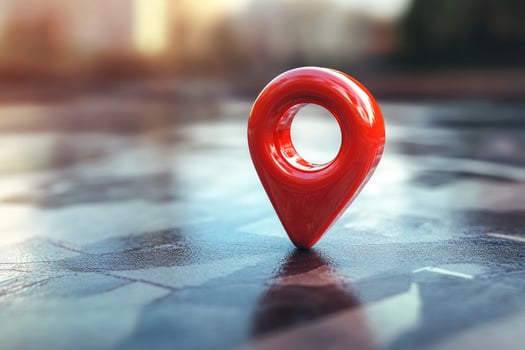 A shiny red map pin marker resting on a wet, reflective surface photo