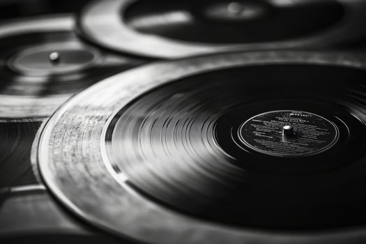 Closeup of vintage vinyl records, showcasing grooves and texture in black and white photo
