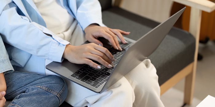 Close-up of hands typing on laptop, showcasing family engagement in learning. photo