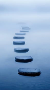 Misty blue water surrounds stepping stones across the river reflecting calmness and peace photo