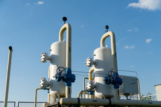Two large pipes with valves and pipes in front of a blue sky photo