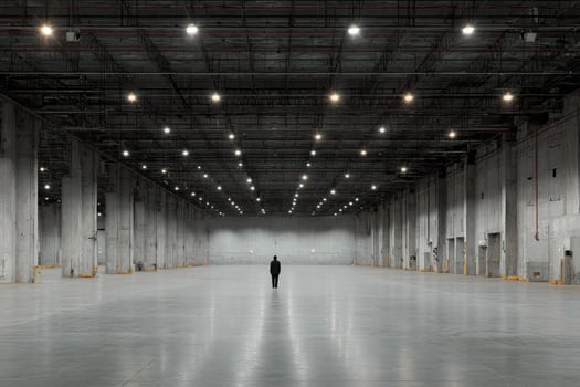 A person standing in an empty warehouse photo