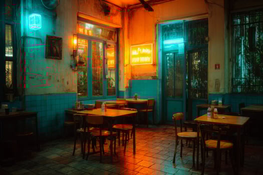 A restaurant with tables and chairs in front of neon signs photo