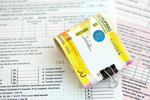 Philippines peso money bills on tax form. Taxation and accounting concept photo
