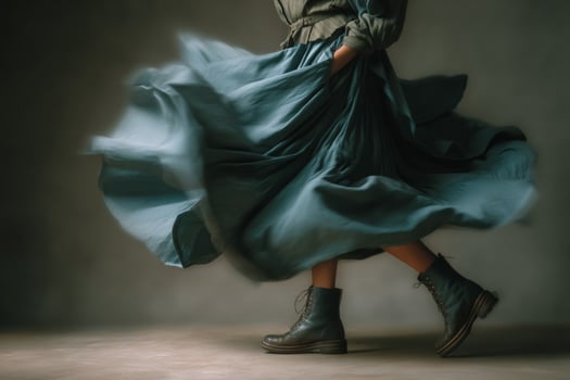 A woman in a blue dress is dancing in the wind photo