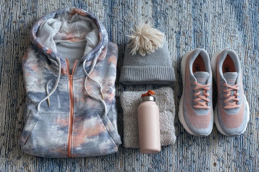 A pair of sneakers, a jacket, a water bottle and a hat photo