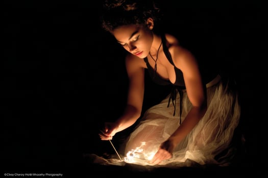 A woman in a dress is lighting a candle photo