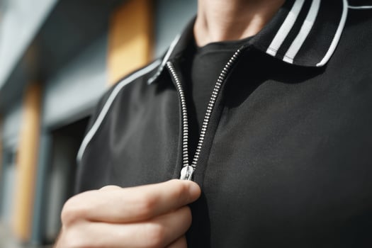 Close up of a man's hand opening a zipper on a black jacket photo
