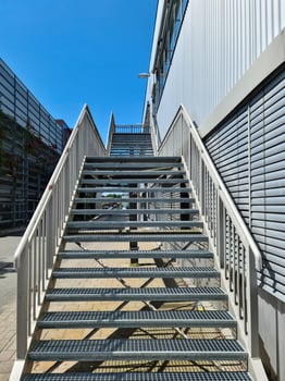 Metal staircase leading to industrial building under blue sky photo