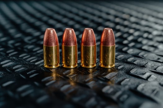 Ammunition. Four 9mm bullets on textured black background photo
