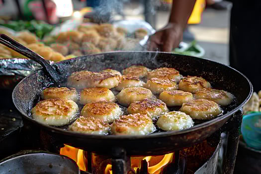 Golden Pan Fried Patties Sizzling Over Open Flames in a Street Food Stall. photo