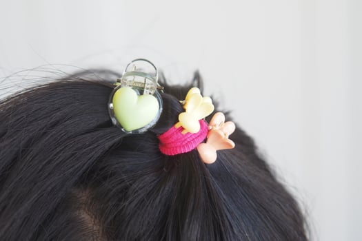 Colorful hair accessories on dark hair in a bright setting photo