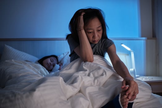 Asian single mom is sleepless, restless leg syndrome, is stressed, awake at night near her girl, with insomnia illness, mature and menopausal woman, family healthcare lifestyle problem. photo