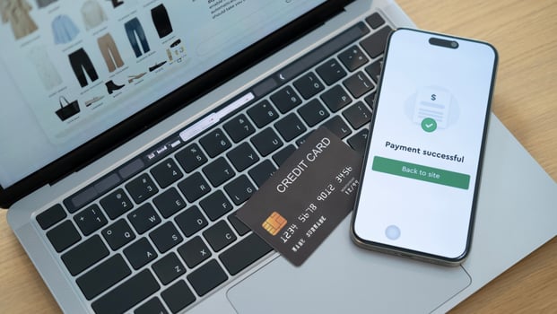 An e-commerce website on a laptop with a credit card and a phone showing payment success, reflecting a smooth and efficient online shopping experience photo