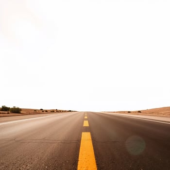 Empty asphalt road disappearing into white horizon in desert landscape photo