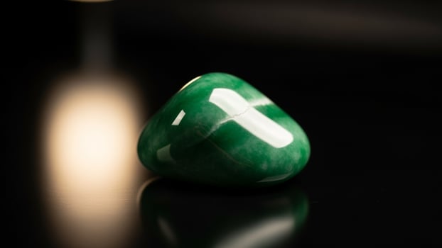 A green stone on a black surface photo