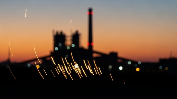 A factory at sunset with lights and smoke photo
