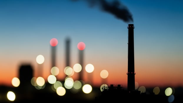 A factory with smoke coming out of the chimney photo