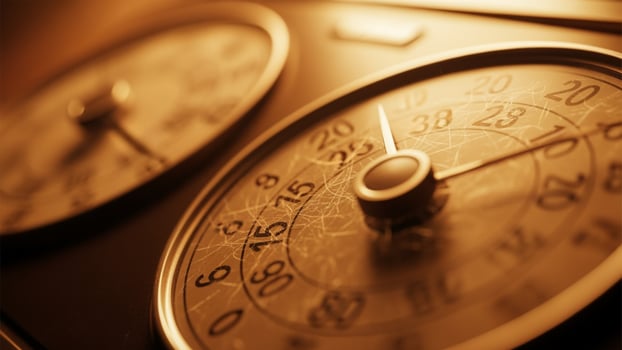 A close up of two clocks on a wooden table photo
