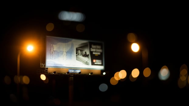 A billboard on the side of a street at night photo