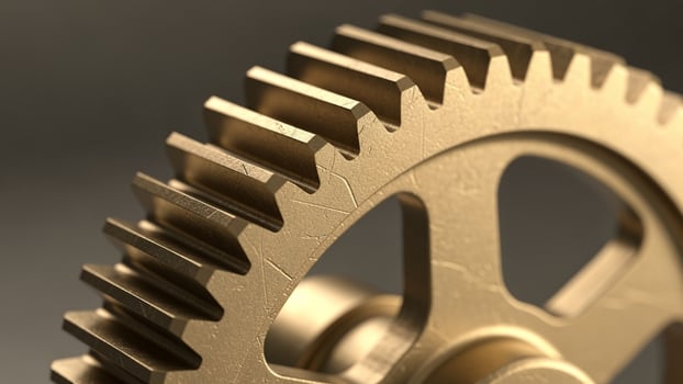 A close up of a golden gear on a gray background photo