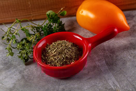 A red measuring cup with herbs and a lemon photo