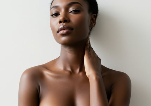 Beautiful African woman with clear skin poses, neck touching in wellness studio photo