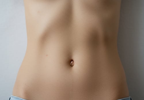 Close-up of a toned stomach against a plain wall, advertising healthy lifestyle photo