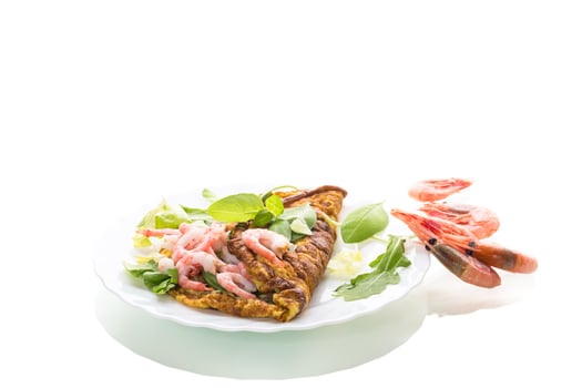 Fried omelette with shrimps and greens on a white background. photo