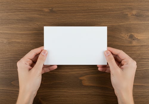 Hands holding blank white paper on wooden desk in office with copy space photo