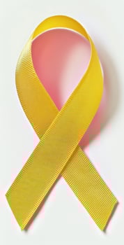 A yellow ribbon is shown on a white surface photo
