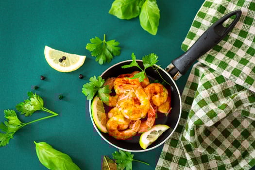 Juicy fried shrimp with lemon slices in the kitchen in a pan photo